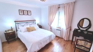 a bedroom with a bed and a mirror and a table at Mirador del castillo in Monforte de Lemos