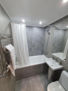 y baño con ducha, bañera y lavamanos. en Auezov Apartment, en Almaty