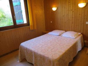 ein Schlafzimmer mit einem Bett mit zwei Kissen und zwei Fenstern in der Unterkunft Appartement Les Gets, 3 pièces, 6 personnes - FR-1-671-88 in Les Gets