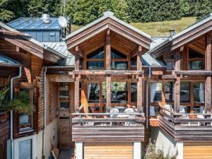 a log home with large windows and a porch at Charmant Chalet aux Gets, 4 Chambres, 8 Pers, Wi-Fi, Garage, Proche Télécabine et Centre - FR-1-671-126 in Les Gets