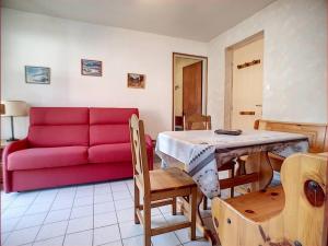 - un salon avec un canapé rouge et une table dans l'établissement Appartement Les Gets, 2 pièces, 4 personnes - FR-1-671-149, aux Gets