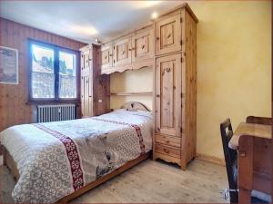 um quarto com uma cama e um armário de madeira em Appartement Les Gets, 2 pièces, 4 personnes - FR-1-671-149 em Les Gets