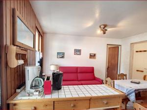 uma sala de estar com um sofá vermelho num quarto em Appartement Les Gets, 2 pièces, 4 personnes - FR-1-671-149 em Les Gets