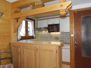 a kitchen with wooden cabinets and a microwave at Appartement Les Gets, 3 pièces, 5 personnes - FR-1-671-231 in Les Gets