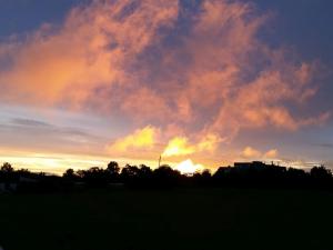 a sunset over a field with the sun in the sky at Ferienwohnungen Karle in Künzelsau