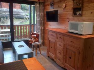 ein Wohnzimmer mit einer Holzhütte mit einem TV darüber in der Unterkunft Appartement Les Gets, 2 pièces, 4 personnes - FR-1-671-103 in Les Gets