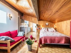 sypialnia z czerwonym łóżkiem i czerwoną kanapą w obiekcie Appartement Les Gets, 2 pièces, 4 personnes - FR-1-671-110 w mieście Les Gets