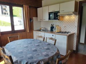 a kitchen with a table and a kitchen with a stove at Appartement Les Gets, 3 pièces, 6 personnes - FR-1-671-228 in Les Gets