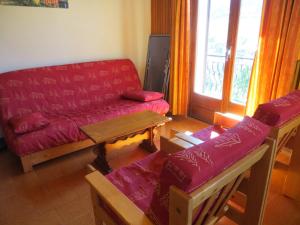 a living room with a red couch and a table at Appartement Les Gets, 3 pièces, 6 personnes - FR-1-671-228 in Les Gets