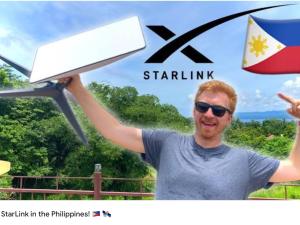 a man holding up a laptop in the philippines at BambooBeachVilla2 AC NEW OCEANFRONT POOL sunsetview garden kitchen SATELLITE STARLINK WI-FI in Dimiao