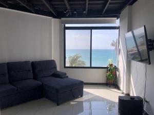 uma sala de estar com um sofá e uma grande janela em Apartamento en excelente ubicación em Manta