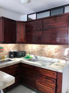 uma cozinha com armários de madeira e um lavatório em Apartamento en excelente ubicación em Manta