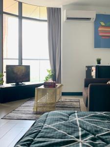 ein Wohnzimmer mit einem Sofa und einem TV in der Unterkunft AmicaHomes Studio 3 Empire City Free wifi & Netflix in Petaling Jaya