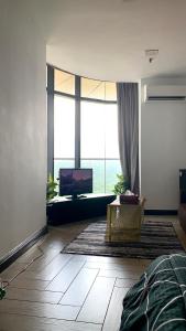 ein Wohnzimmer mit einem TV und einem großen Fenster in der Unterkunft AmicaHomes Studio 3 Empire City Free wifi & Netflix in Petaling Jaya