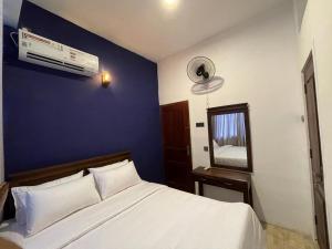 een slaapkamer met een wit bed en een blauwe muur bij Kandy City Inn in Kandy