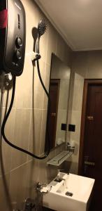 een badkamer met een föhn aan de muur naast een wastafel bij Kandy City Inn in Kandy