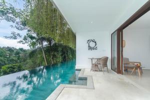 uma piscina no meio de uma casa com vista em The Hidden Paradise Ubud - CHSE Certified em Ubud
