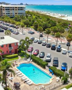 an aerial view of a parking lot with a pool and the beach at Majestic Beach Condo with Heated POOL in St Pete Beach in St Pete Beach