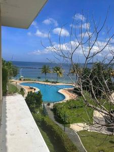 a swimming pool with the ocean in the background at Modern Chic Beachfront Unit at Canyon Cove Nasugbu in Nasugbu