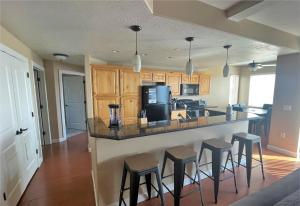 a kitchen with a bar with stools and a microwave at Deluxe Downtown Condo Close to Everything! in Salt Lake City
