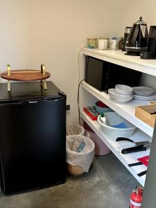 una cocina con nevera negra y estanterías blancas en EcoLuxe en Dunsborough