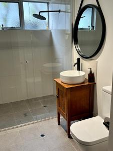 uma casa de banho com um lavatório e um chuveiro com um espelho. em EcoLuxe em Dunsborough