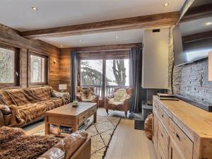 Una sala de estar con muebles de cuero y una pared de ladrillo. en Chalet rénové au pied des pistes avec balcon et cheminée - FR-1-455-231, en La Plagne Tarentaise