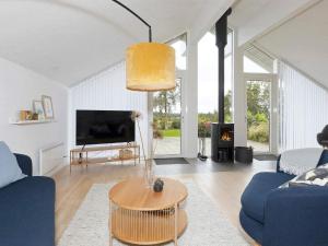 - un salon avec un canapé bleu et une table dans l'établissement Holiday home Højslev, à Højslev