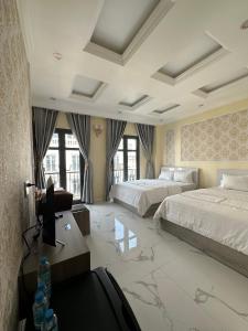 RUBY HOTEL في Tây Ninh: غرفة نوم كبيرة بسريرين وتلفزيون