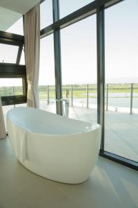 una gran bañera blanca en una habitación con ventana en Golden Harvest Homestay, en Toucheng