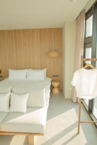 a bedroom with a white bed and a couch at Golden Harvest Homestay in Toucheng