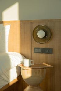 Un dormitorio con una cama y una mesa con una taza. en Golden Harvest Homestay, en Toucheng