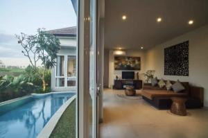 ein Haus mit einem Pool und einem Wohnzimmer in der Unterkunft Araya Luxe Villa in Munggu