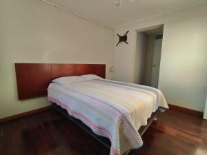 Un dormitorio con una cama con una manta a rayas. en Departamento duplex en JLByR en Arequipa