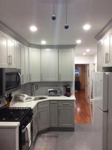 a kitchen with white cabinets and a white refrigerator at Cozy Canarsie Getaway Brooklyn NY in Brooklyn