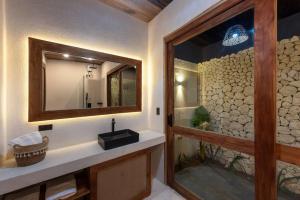 a bathroom with a sink and a mirror at Villa Baleia Siargao in San Isidro