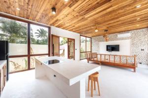 a kitchen with a large island in a room with windows at Villa Baleia Siargao in San Isidro