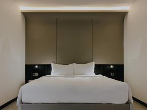 a large bed with white sheets and pillows at The Concept Hotel HCMC- District 1 in Ho Chi Minh City