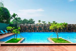 una gran piscina con dos árboles. en Le Meridien Nagpur en Nagpur