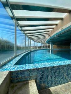 una gran piscina con azulejos azules en un edificio en Linda Bay 614, en Mar de las Pampas