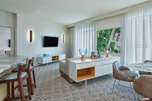 a living room with a dining table and a television at Art Ovation Hotel, Autograph Collection in Sarasota
