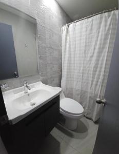 y baño con lavabo, aseo y espejo. en Hotel Regata, en Iquique