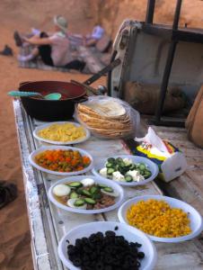 una mesa con cuencos de diferentes tipos de alimentos en Bedouin bunch camp, en Wadi Rum