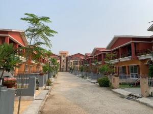 an empty street with houses and palm trees at Bolpur Shantiniketan Bungalow on Kopai River in Shānti Niketan