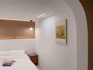 1 dormitorio con 1 cama y una foto en la pared en Onheim en Tongyeong