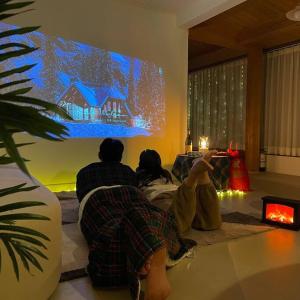een groep mensen die in een woonkamer tv kijken bij Onheim in Tongyeong