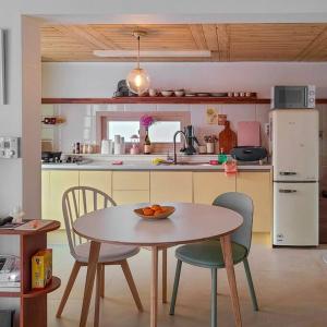 a kitchen with a table and two chairs and a table with a bowl at Onheim in Tongyeong