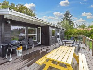 a wooden deck with a picnic table and a grill at Holiday home Farsø VIII in Farsø