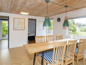 a dining room with a wooden table and chairs at Holiday home Farsø VIII in Farsø