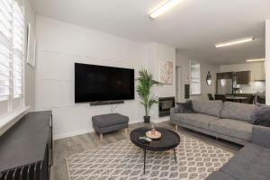 a living room with a couch and a flat screen tv at Azami - Charming Gilbert Cottage in Adelaide
